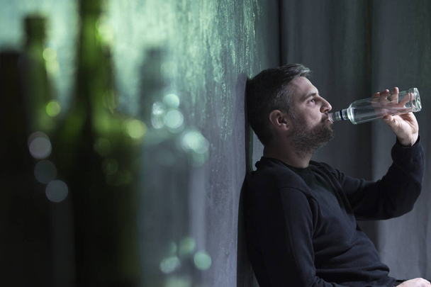Man wearing black drinking alcohol - Фото, изображение