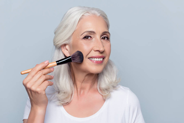 Middle aged, attractive, caucasian, nice woman applying makeup o - Foto, immagini