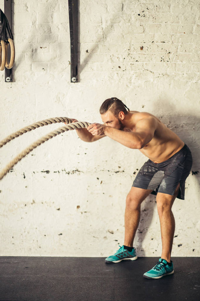 Men with battle rope battle ropes exercise in fitness gym - Foto, Imagem