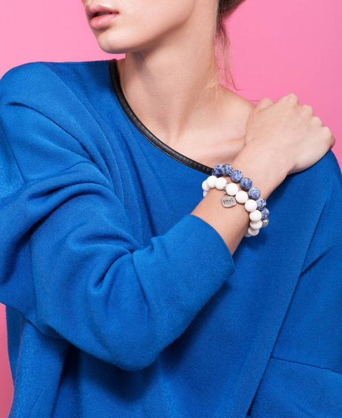 The bracelet on the wrist of a young woman closeup. Handmade accessories - Φωτογραφία, εικόνα