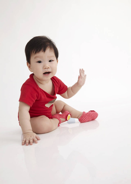 A kínai baby ül a fehér háttér bemutatása - Fotó, kép