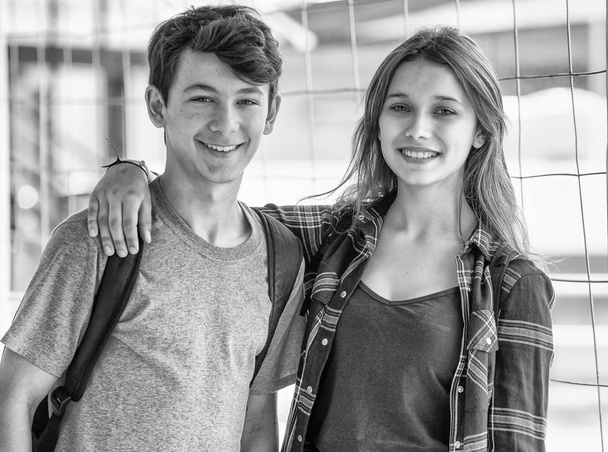 Οι έφηβοι καυκάσιος Ζευγάρι hapoy χαμογελώντας και Αγκαλιάζοντας στο σχολείο - Φωτογραφία, εικόνα