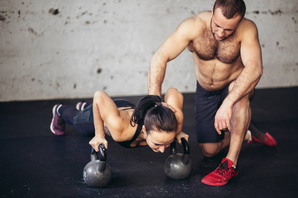 trainer man and woman push-up strength pushup in a fitness workout - Photo, Image