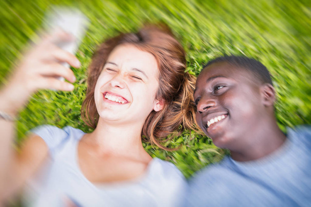 アフロ アメリカンの男の子と白人の女の子は草幸せ m に敷設 - 写真・画像