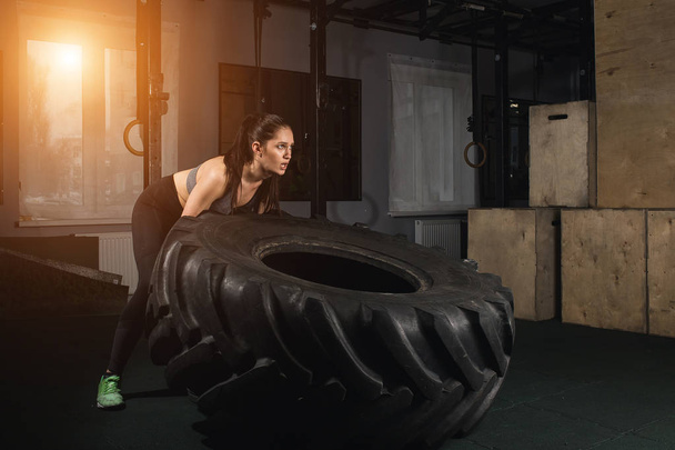 female flipping tire at the gym. - Foto, imagen
