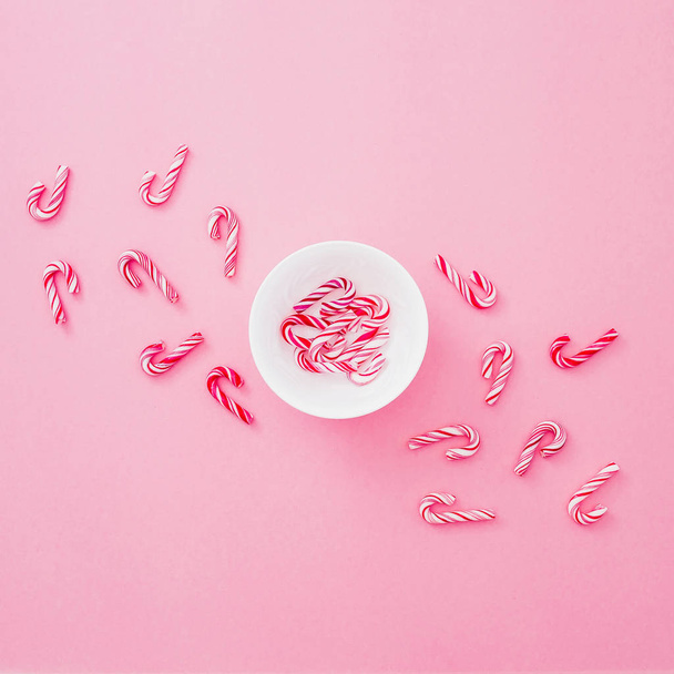 Traditional Christmas candy canes isolated on pink  background, copy space. Flat lay holiday concept. - Photo, image