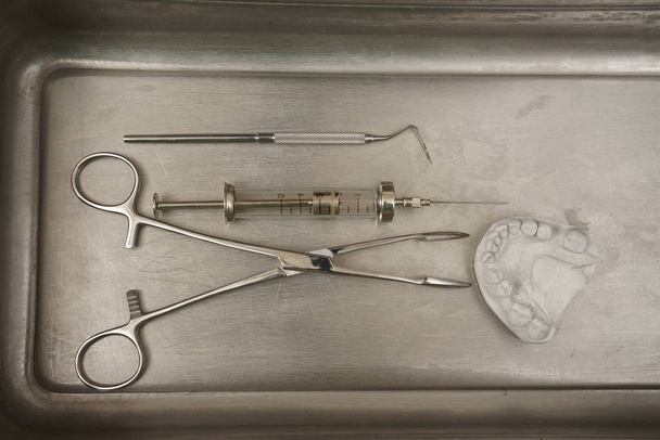 Varios equipos dentales aislados sobre fondo de hierro metálico. vista de primer plano del conjunto de herramientas dentales
  - Foto, Imagen