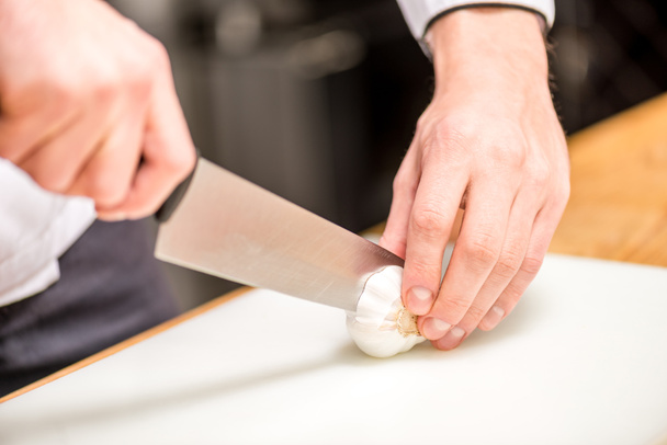 cropped image of chef cutting garlic - Fotoğraf, Görsel