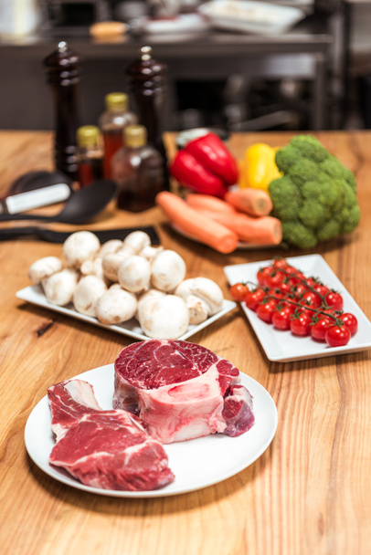 carne cruda y verduras crudas sobre mesa de madera
 - Foto, Imagen
