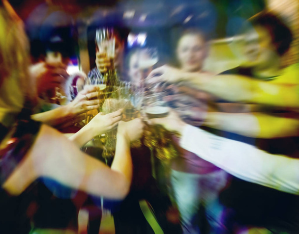 Blurred image. Group of best friends toasting with beer at cafe - Teenagers having fun eating pizza together at lunch time - Foto, Bild