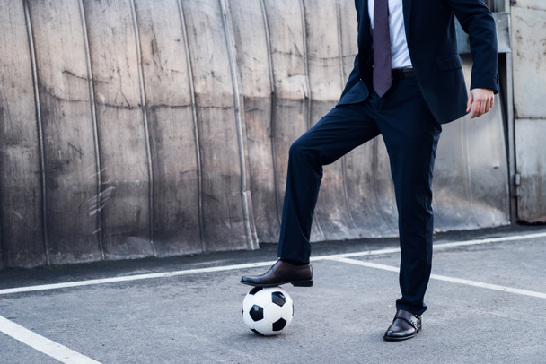 partial view of businessman in suit playing soccer on street - Photo, Image