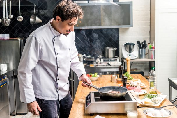 guapo chef freír carne en restaurante cocina
 - Foto, imagen