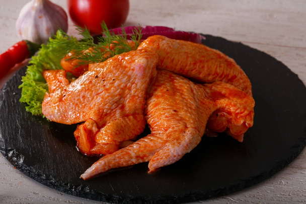 Сырые куриные крылышки для приготовления пищи на барбекю, на деревянном фоне
 - Фото, изображение