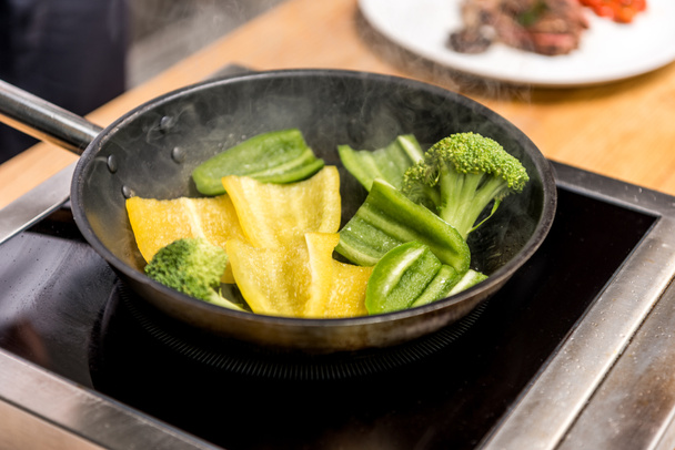 желтый и зеленый перец с брокколи на сковороде
 - Фото, изображение