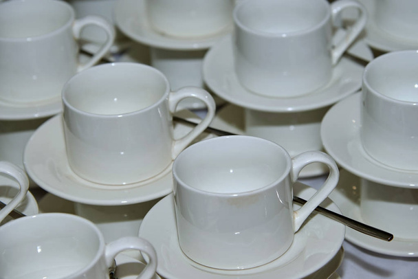 Una tazza da tè bianca vuota è una tazza, con o senza manico, generalmente piccola che può essere afferrata con il pollice e una o due dita.
. - Foto, immagini