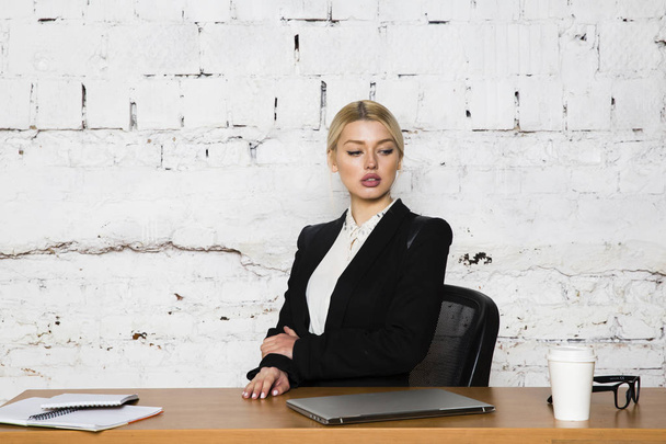 Young blond beauty businesswoman sitting at a office table with laptop, notebook and glasses in suit. Business concept. - Foto, Imagem