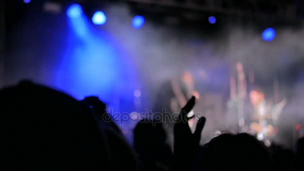 Silhouetten von feiernden und klatschenden Menschen bei Rockkonzert vor der Bühne - Filmmaterial, Video