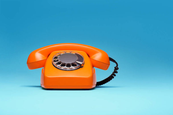 Telephone in retro style on blue background. - 写真・画像
