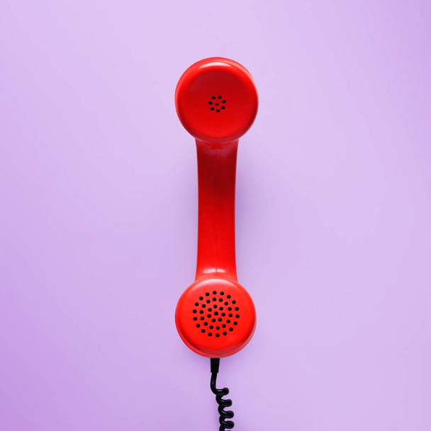 Red telephone in retro style on purple background. - Фото, зображення