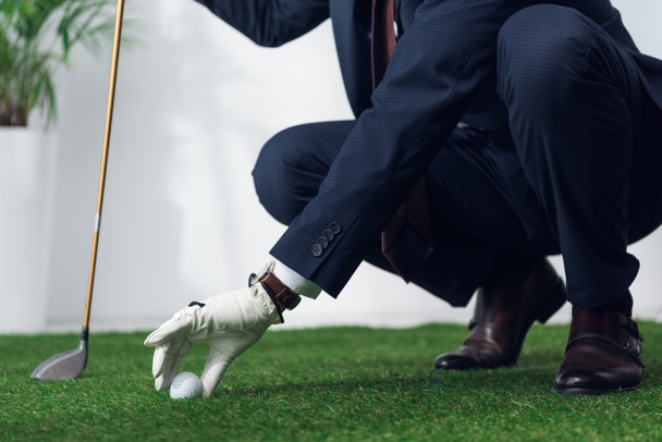 περικοπεί shot του επιχειρηματία σε κοστούμι και γάντι παίζει γκολφ στο γραφείο - Φωτογραφία, εικόνα