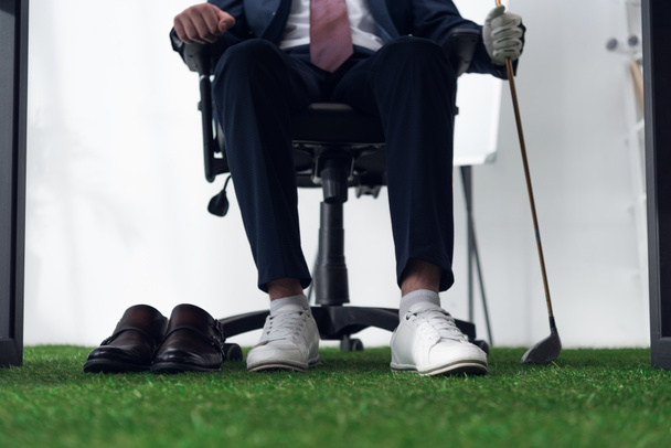 partial view of businessman with golf equipment  in office - Fotoğraf, Görsel