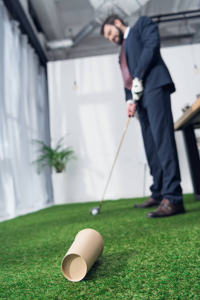 selective focus of young businessman playing golf in office - Φωτογραφία, εικόνα