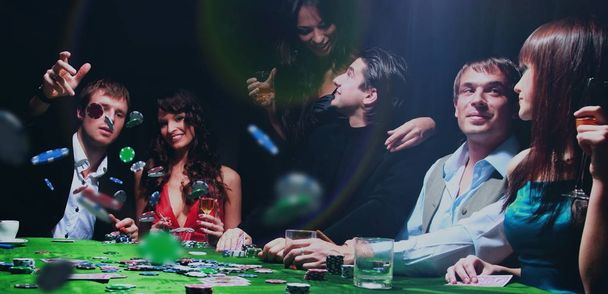 Poker players sitting around a table at a casino - Photo, Image