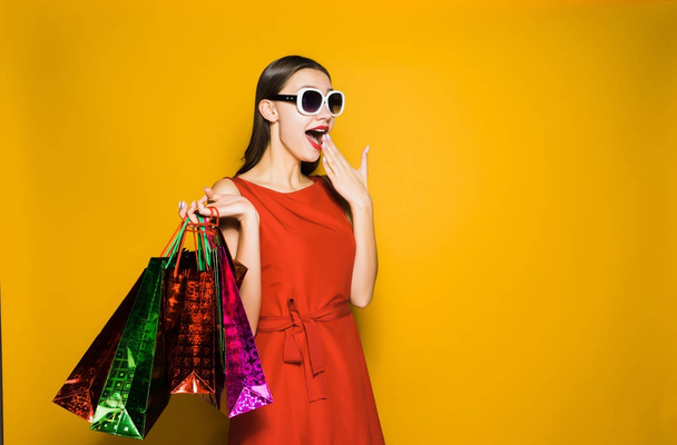 surprised happy young girl shopaholic in sunglasses is surprised by big discounts and black Friday - Foto, Imagem