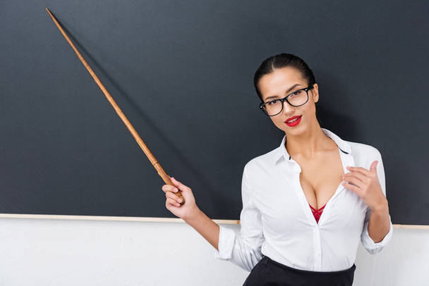 young seductive teacher pointing at chalkboard - Фото, изображение