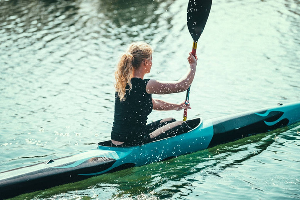 Vrouwelijke kayaker training op lake - Foto, afbeelding