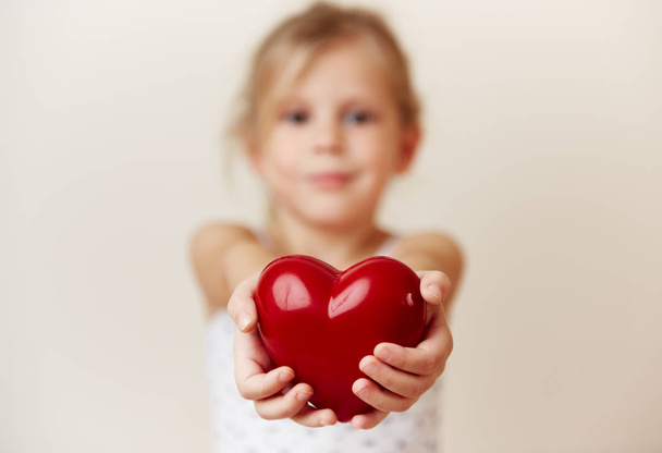 Pretty girl holding big red heart. Concept of love, charity and peace. - Foto, Imagem
