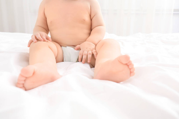 Little baby sitting on bed, closeup - Photo, image