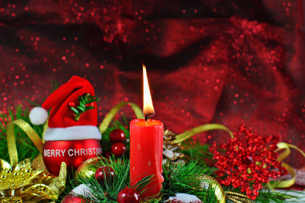 Bougie brûlante avec boule rouge avec chapeau de Père Noël et décorations de Noël
 - Photo, image
