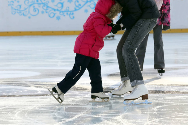 little girl with mother skate on the rink - Фото, изображение