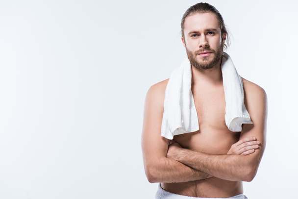 Cheerful caucasian man with bath towel around his neck looking at camera with arms crossed, isolated on white - Foto, Imagem