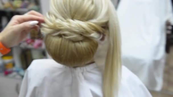 Peluquería hace que el peinado de noche primer plano en el cabello rubio de la mujer de negocios en el salón de belleza
 - Metraje, vídeo