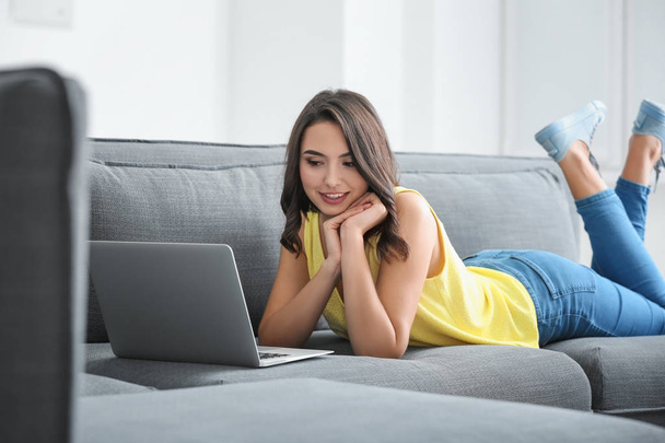  woman with laptop lying on sofa - Zdjęcie, obraz