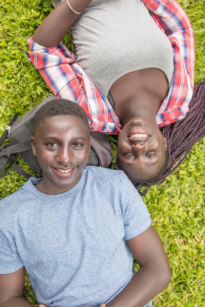 Heureux adolescents souriants. Couple afro-américain étendu dans l'herbe
 - Photo, image