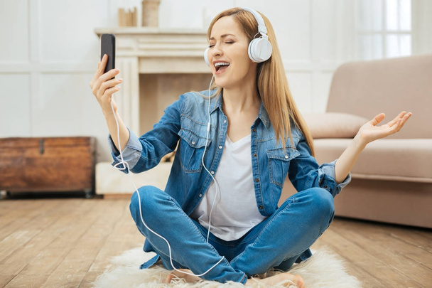 Cheerful woman singing while listening to music - Φωτογραφία, εικόνα