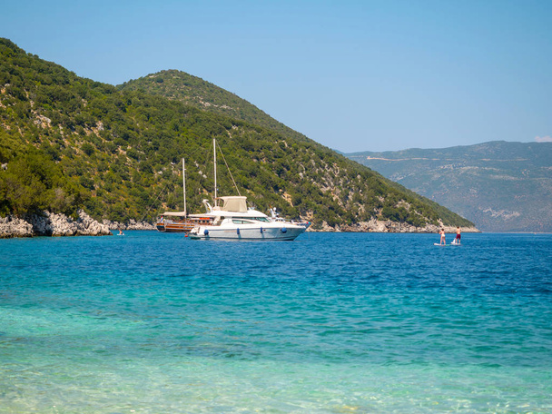 Boats in a shore and people enjoy the summer in Kefalonia island, Greece - Photo, Image