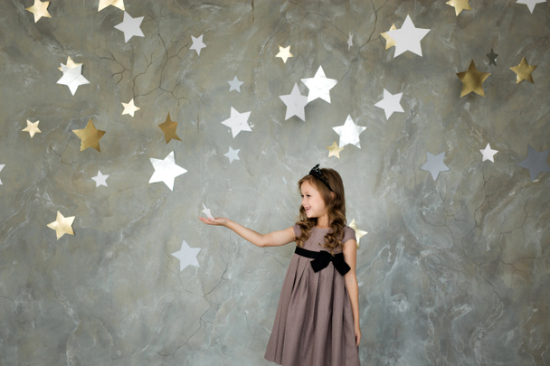 Yıldızlar arka plan ile poz mutlu küçük kız portresi - Fotoğraf, Görsel