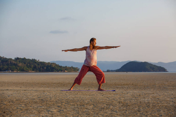 Man is doing yoga on the beach - Фото, зображення