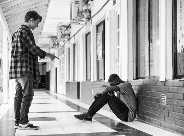 Iskolai zaklatás. Afro-amerikai fiú kétségbeesett, miközben iskolatársa hektár - Fotó, kép