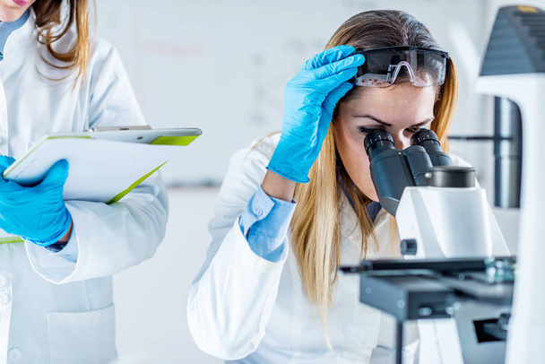 Θηλυκό βιοτεχνολογίας επιστήμονες που εργάζονται στο εργαστήριο - Φωτογραφία, εικόνα