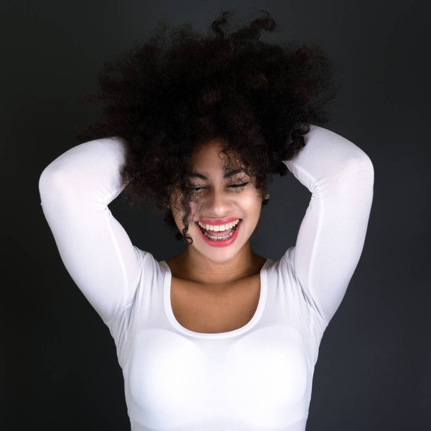Joven mujer negra con peinado afro sonriendo
.  - Foto, Imagen