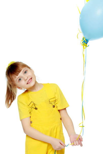 Girl with a short bangs on her head and bright yellow overalls. - Photo, image
