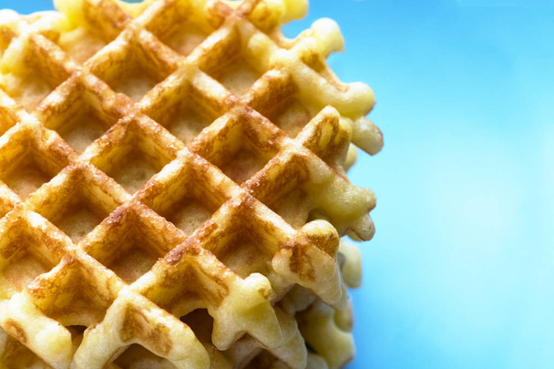 overview of a fleshly baked Belgium waffles showing a blue background for copy space such as menus, recipes and text  - Photo, image