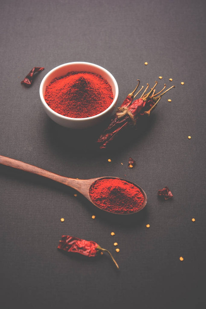 Polvo rojo frío en un tazón con chiles rojos secos sobre fondo colorido o montón de polvo de chile rojo sobre fondo liso
 - Foto, Imagen