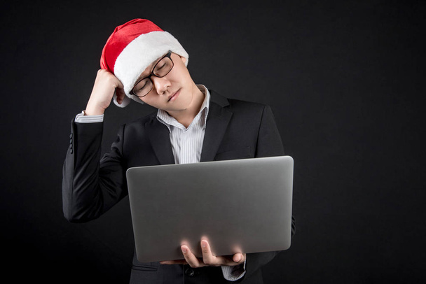 Young Asian businessman with santa hat feeling stress - Foto, afbeelding