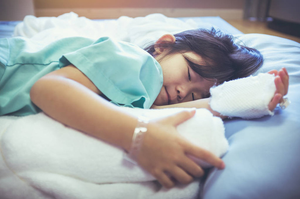 Enfermedad niño asiático ingresado en el hospital con solución salina intravenosa (IV) en la mano
. - Foto, imagen